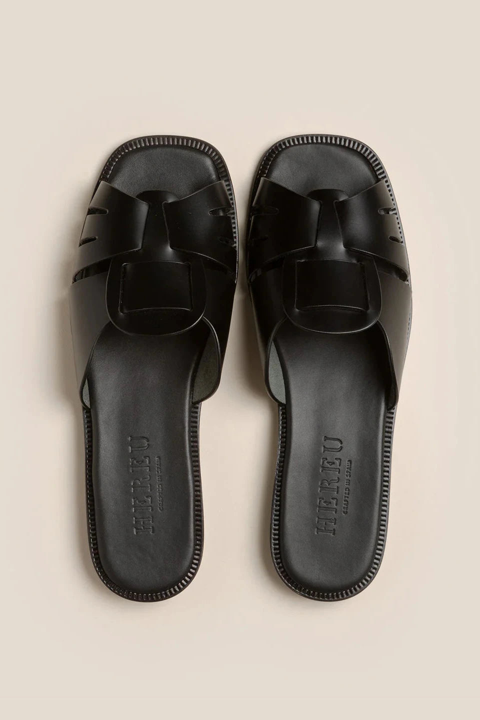 Black sandal on a beige background