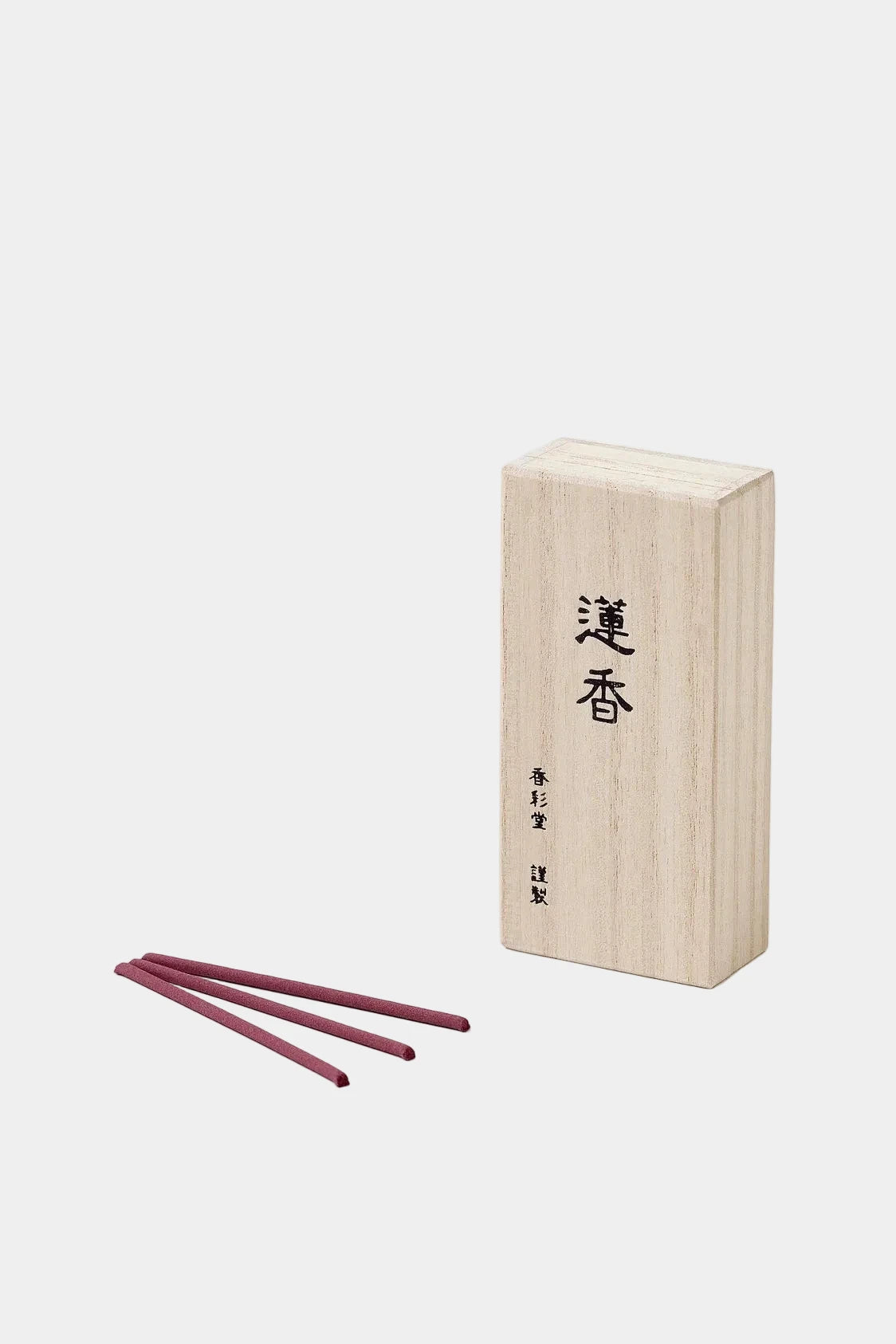 Wooden incense box with two red incense sticks on a white background