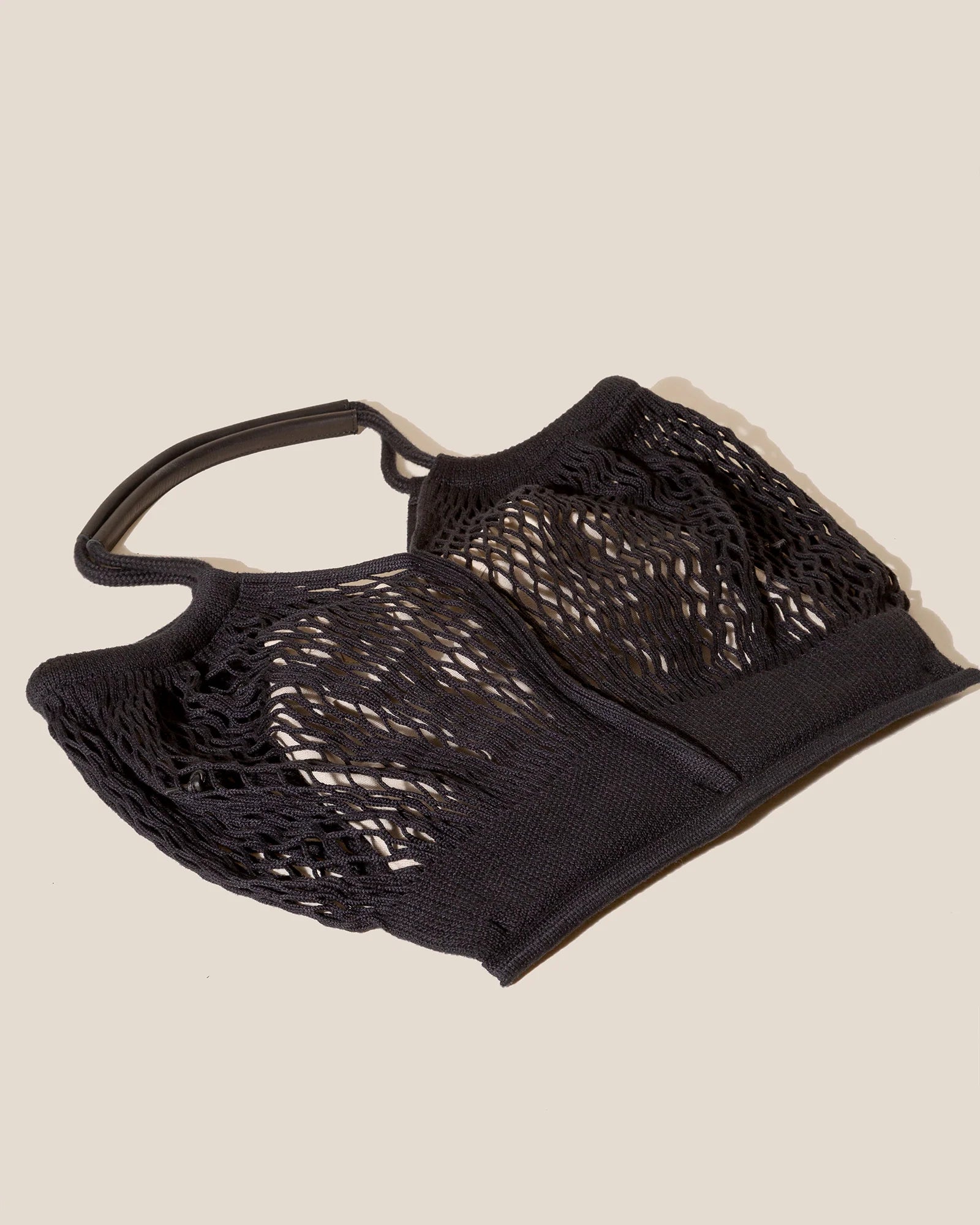 Black mesh bag on a beige background