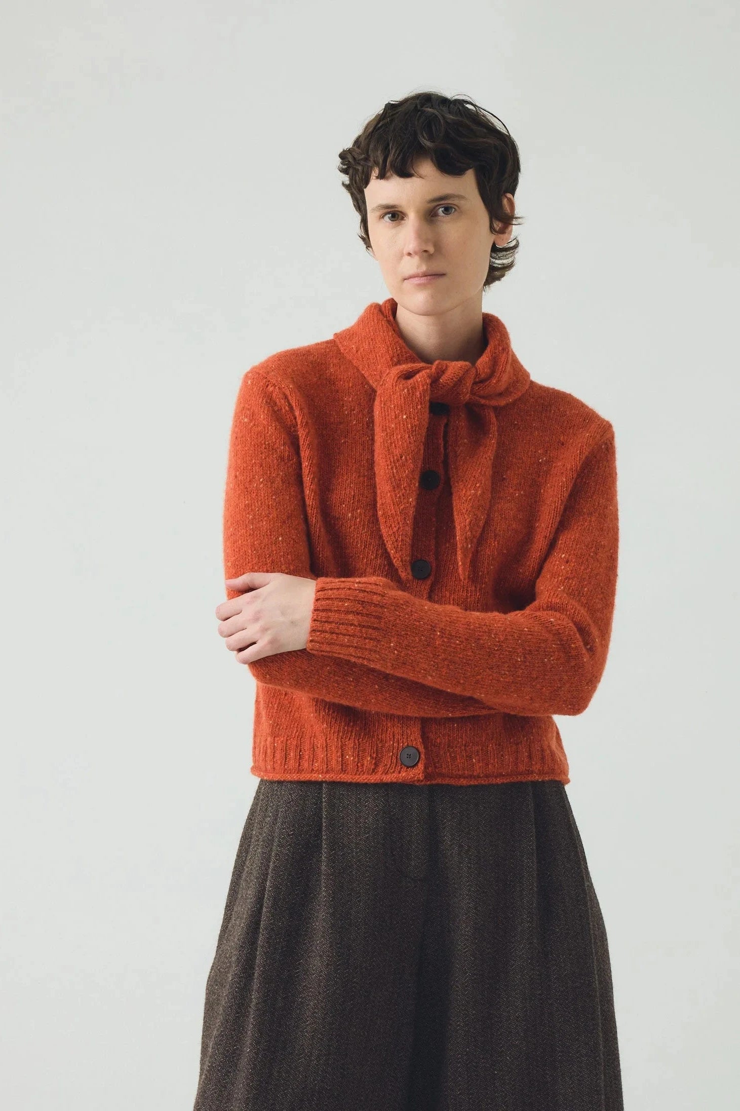 Person wearing an red knitted cardigan on a white background