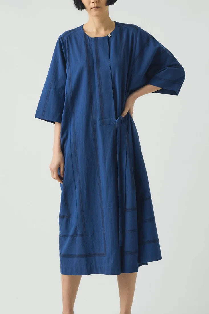 Woman wearing a blue dress against a white background