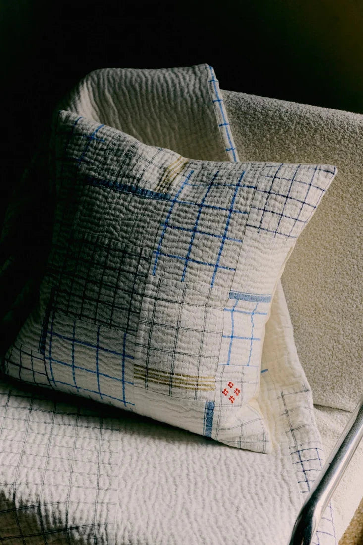 Textured pillow with grid pattern on a neutral background