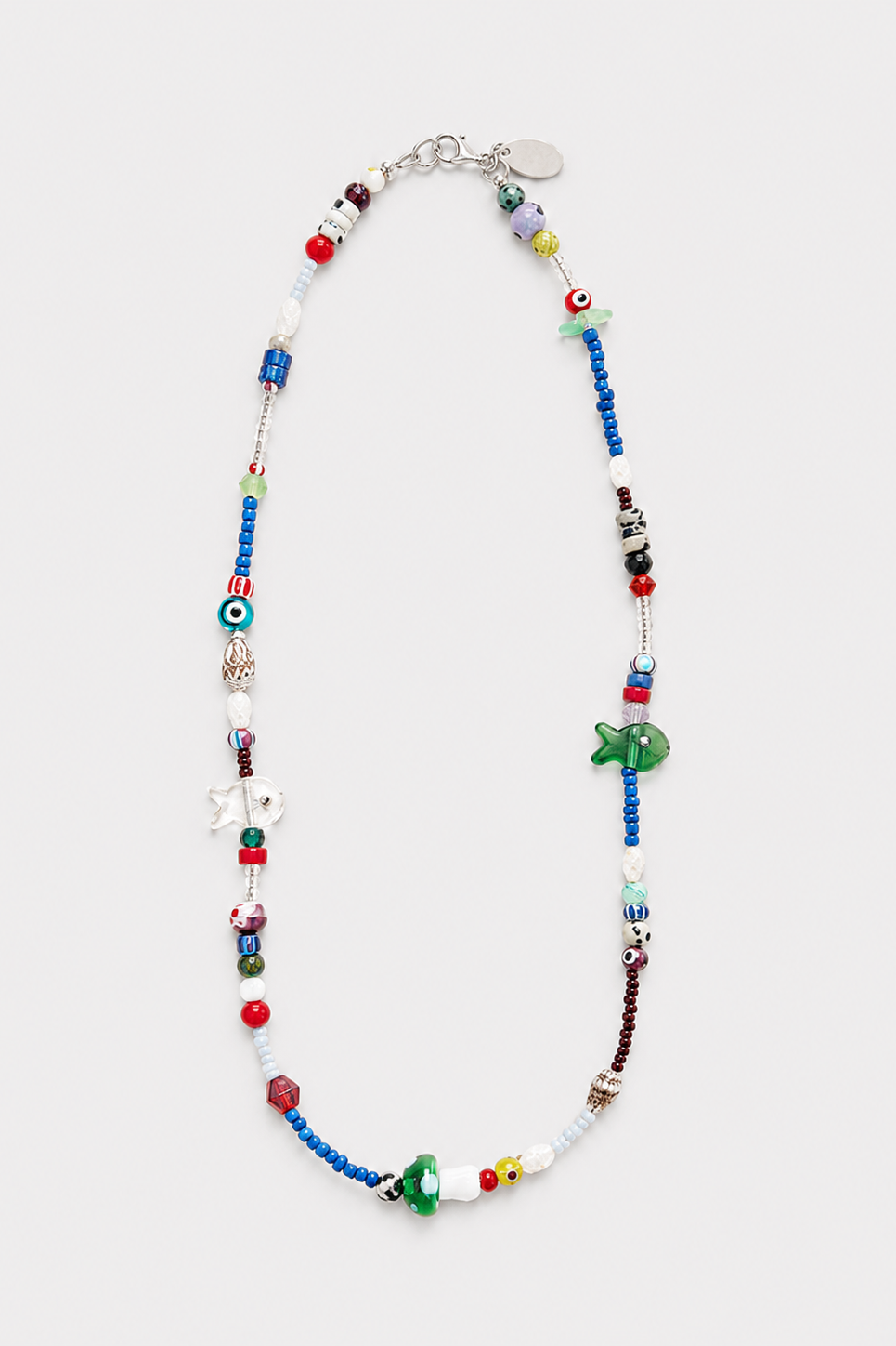 A long beaded necklace featuring a mix of colorful glass beads, white beads, charms, and green fish-shaped beads, finished with sterling silver hardware displayed on a light gray background - East Coast General