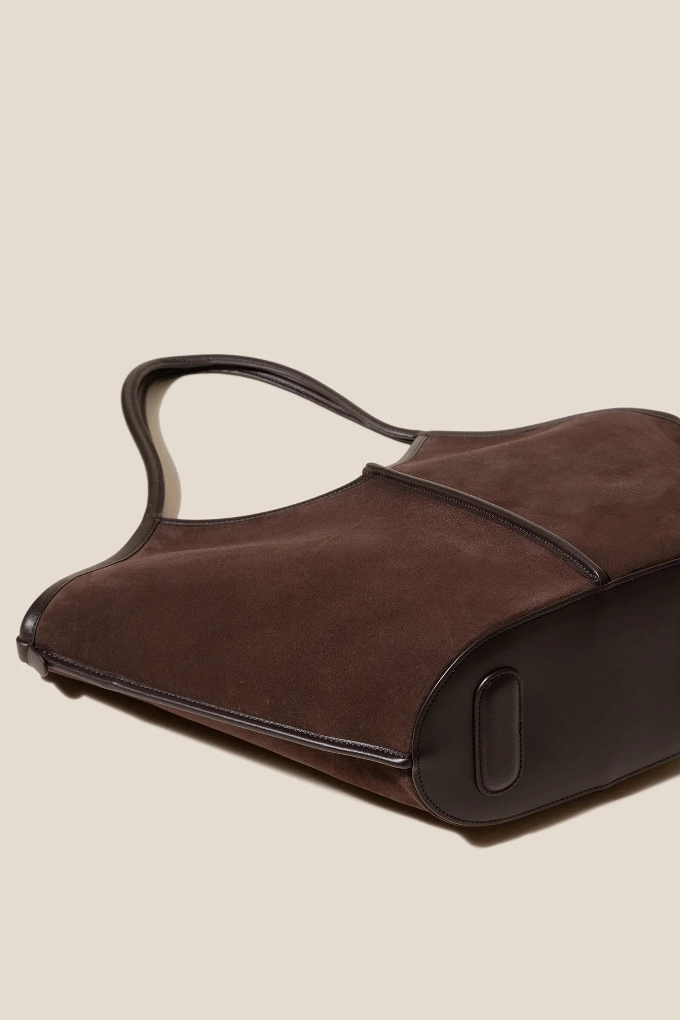 Brown leather handbag on a beige background