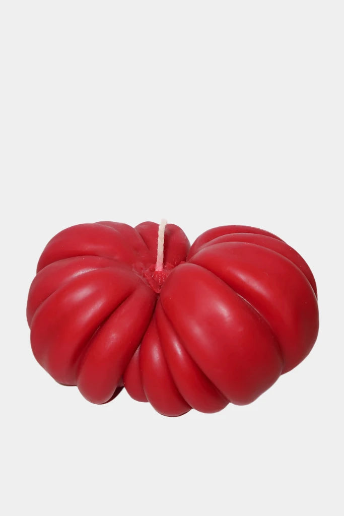 Heirloom red tomato candle on white background 
