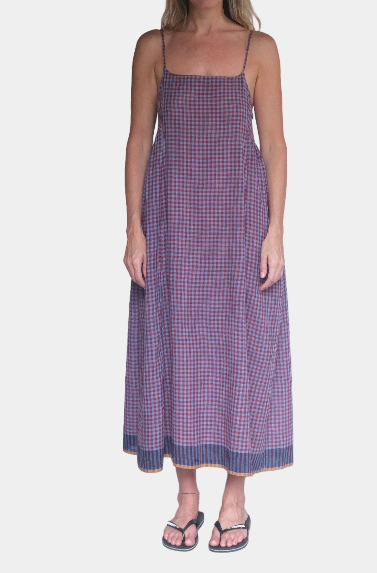 Person wearing a red and blue checkered dress against a white background