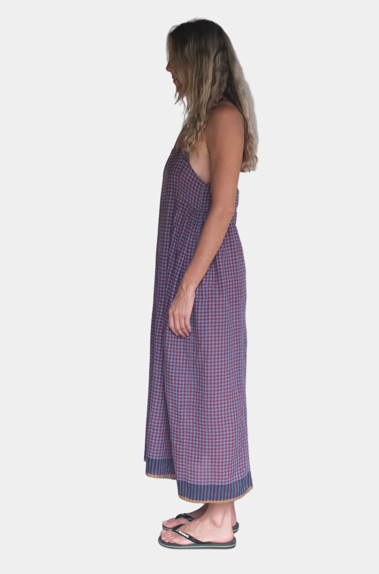 Person wearing a red and blue checkered dress against a white background