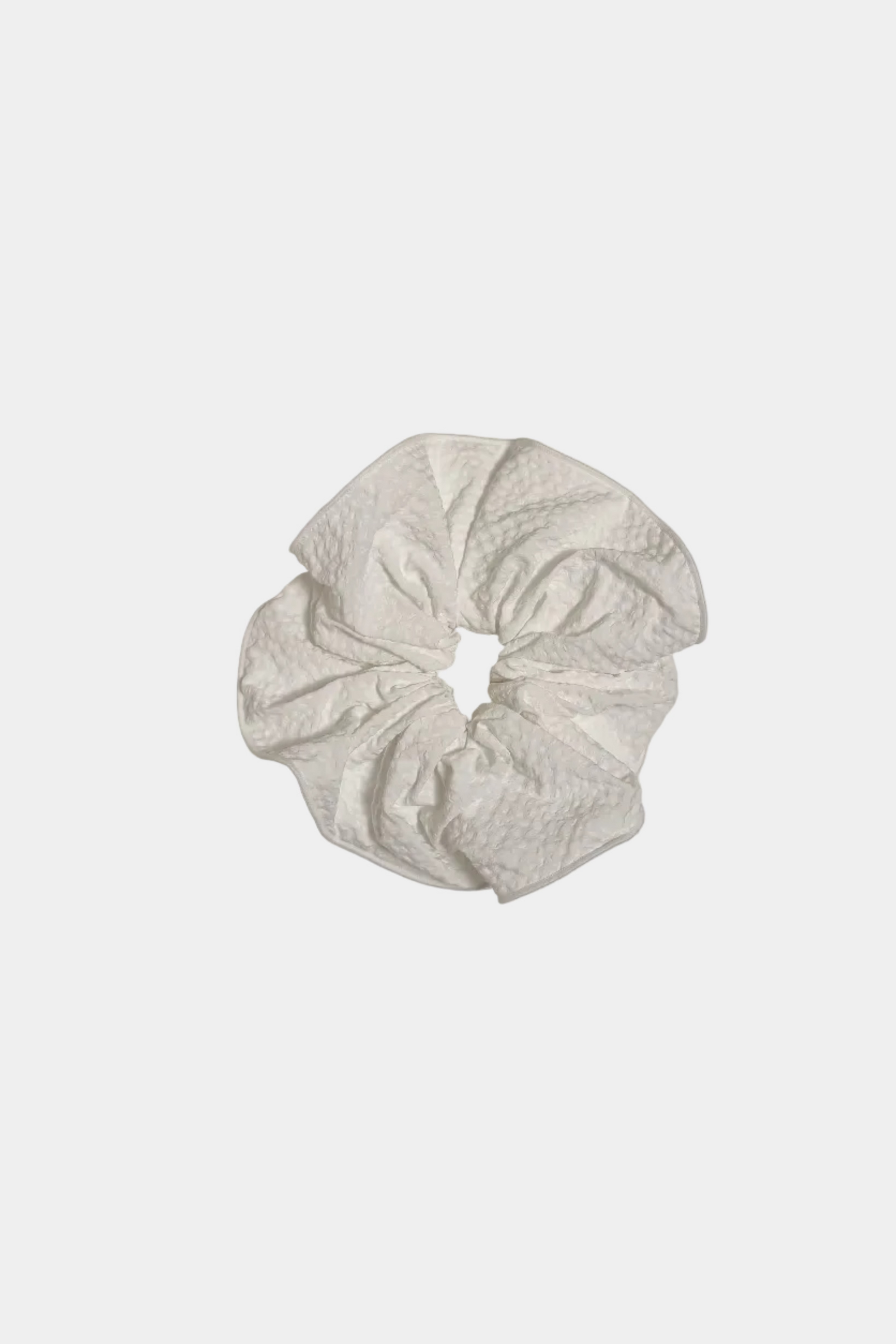 White lace scrunchie on a light gray background