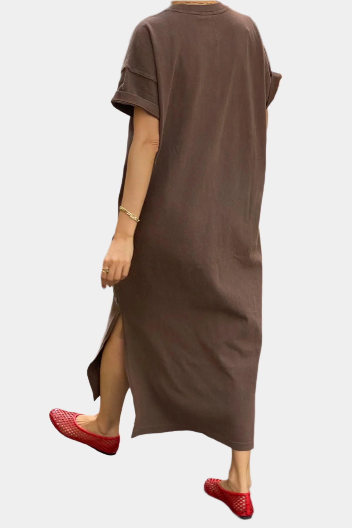a girl walking towards the camera wearing Her Dress in choloate with red jelly shoes