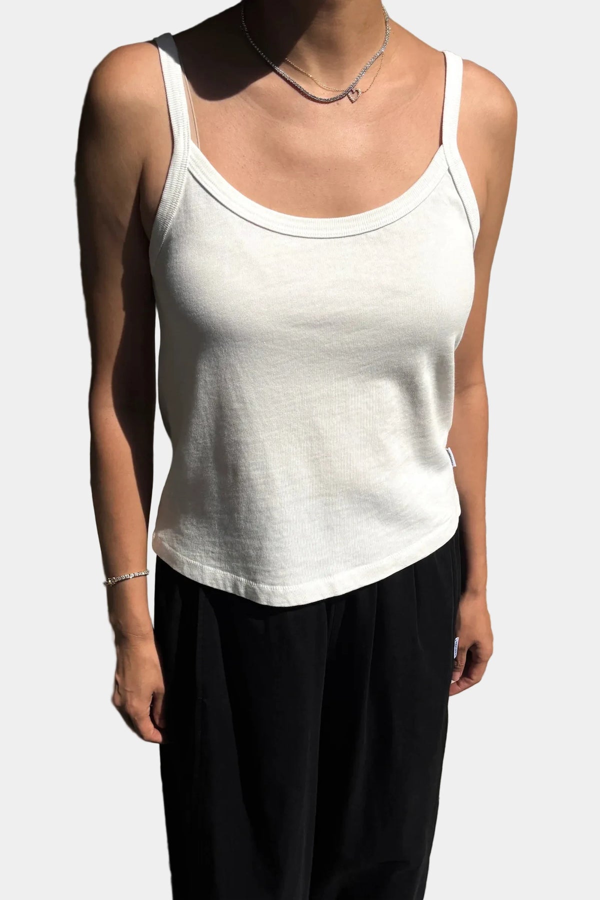Front view of model wearing Le Bon Shoppe Vintage White Premium Jersey Dana Cami with black trousers