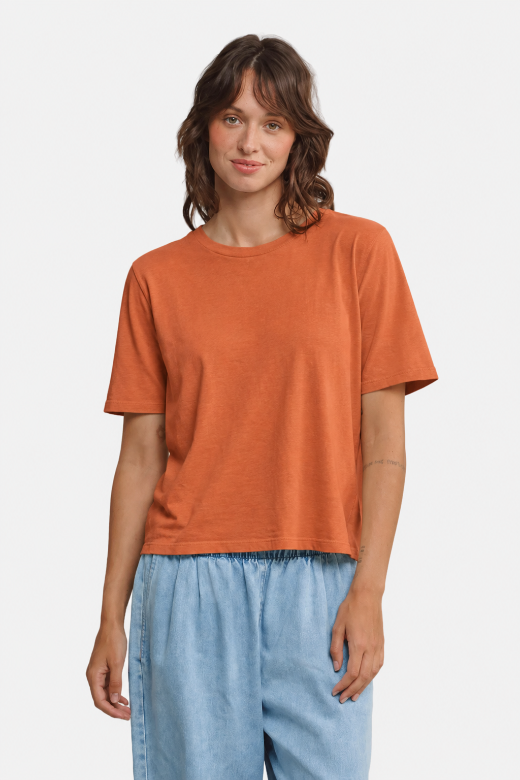 A person wearing the Jungmaven Silverlake Tee in Pumpkin Spice with pale denim pants - East Coast General