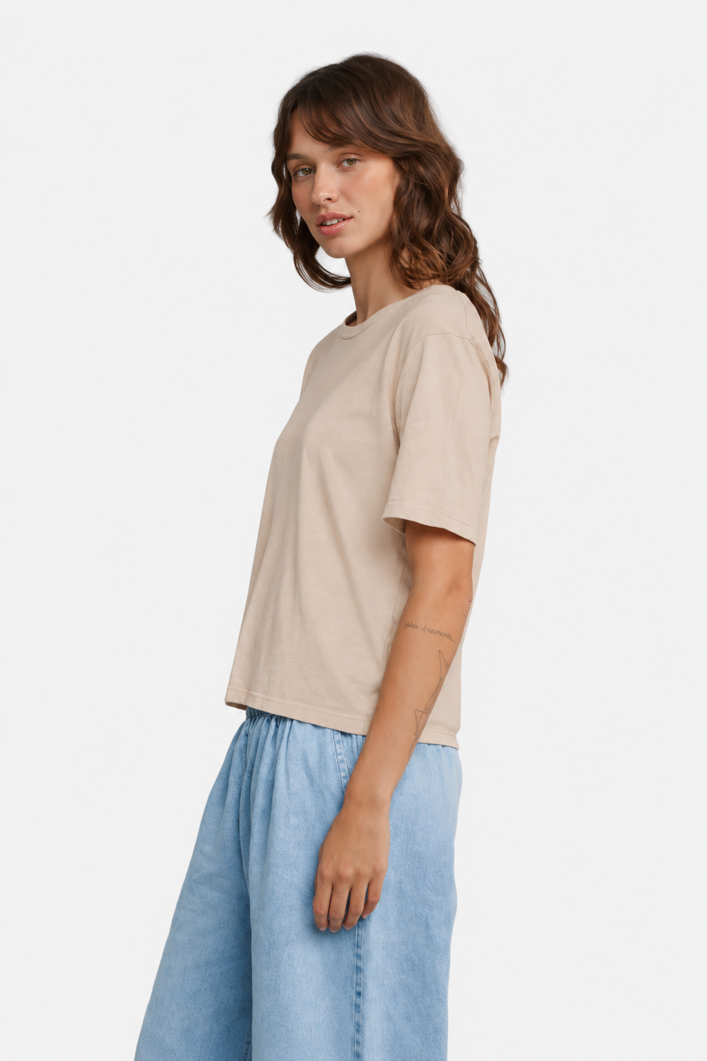 Model wearing the Jungmaven Silverlake tee in Stucco Beige, viewed from the side - East  Coast General