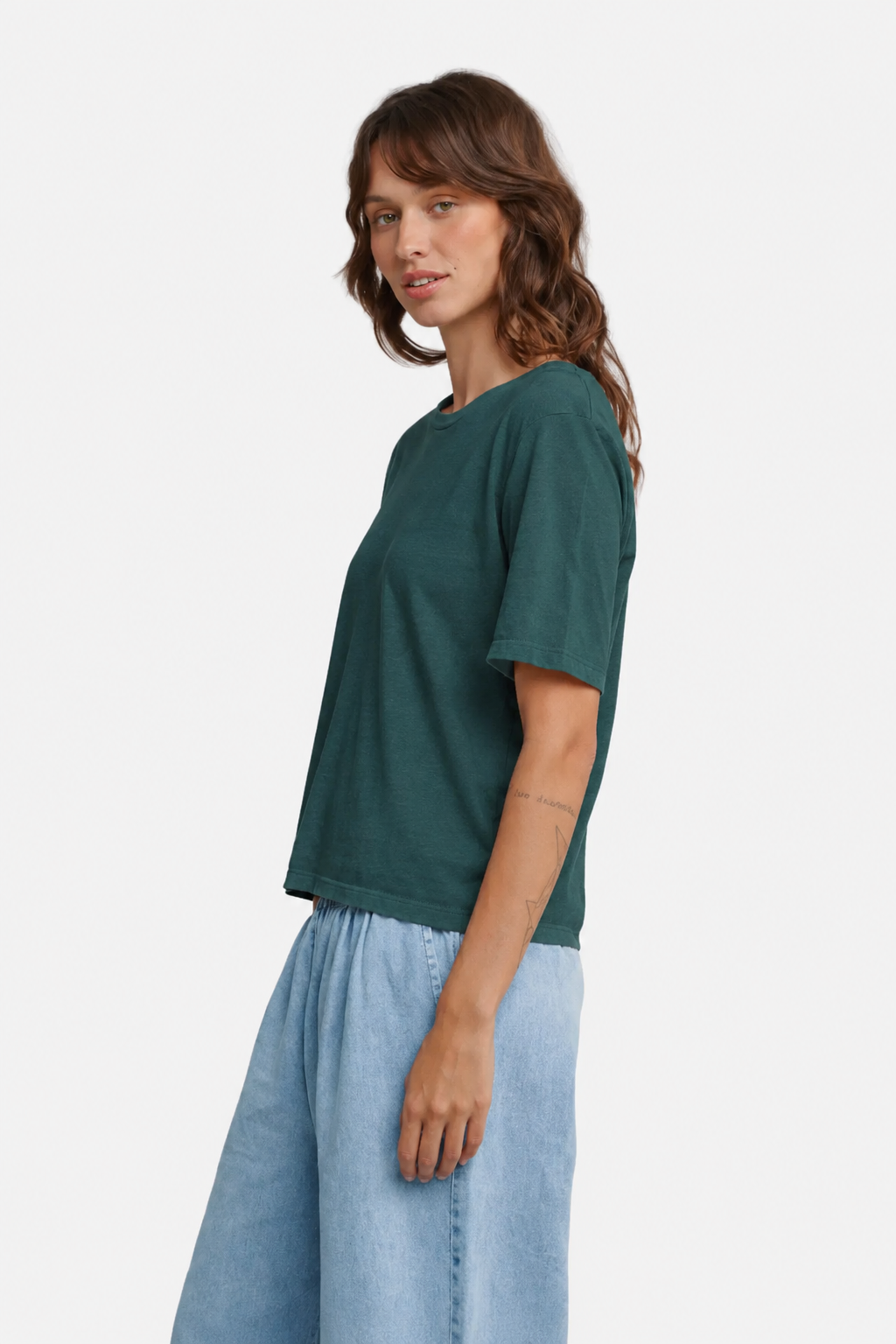 Model wearing the Jungmaven Silverlake tee in Deep Teal viewed from the side - East Coast General