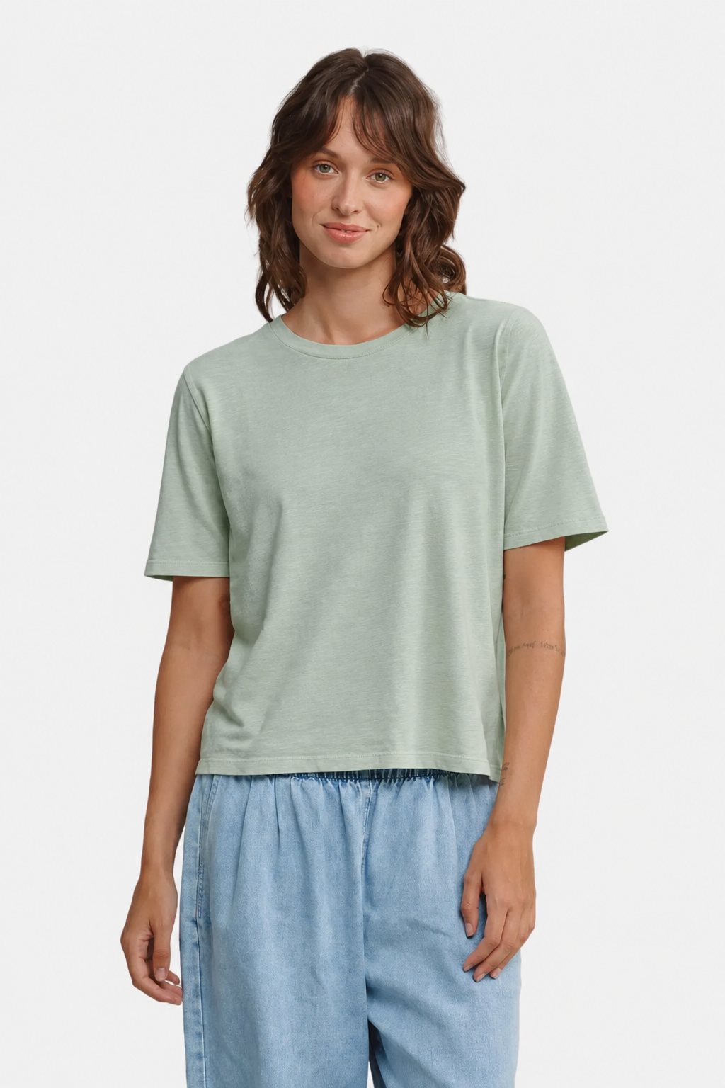 A person wearing the Jungmaven silverlake tee in Stormy Green - East Coast General