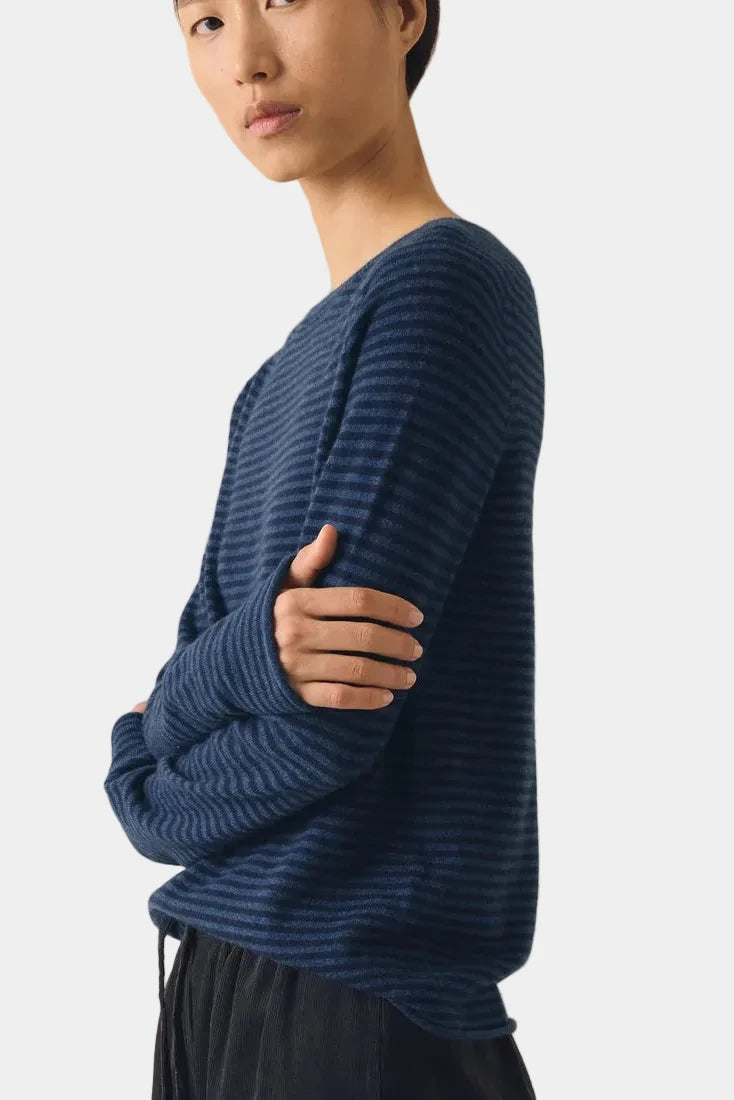 Side profile of model wearing TOAST Denim Blue fine stripe cashmere sweater showing saddle shoulder details