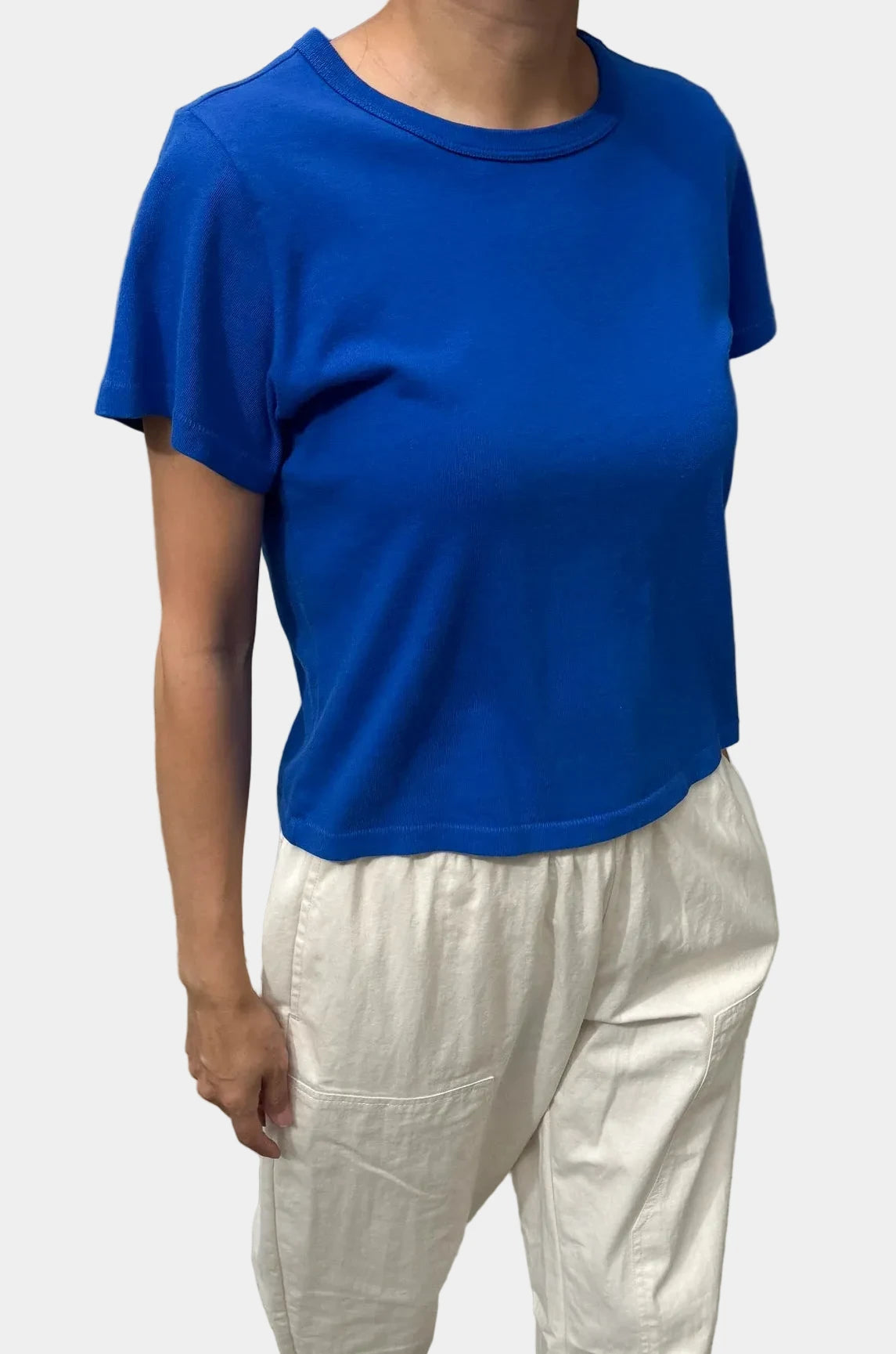 Angled view of model wearing Le Bon Shoppe Cobalt Little Boy Tee with ecru trousers