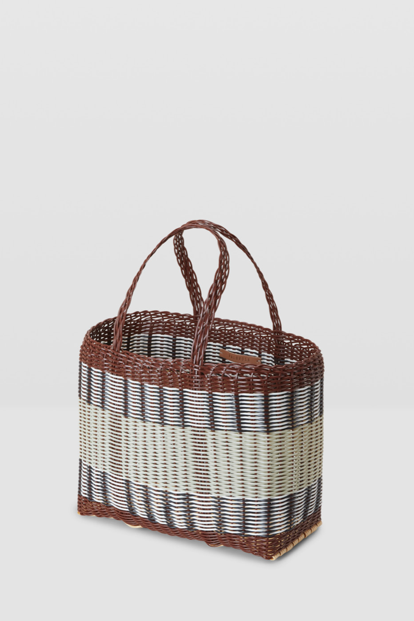 Woven basket with striped pattern on a light gray background