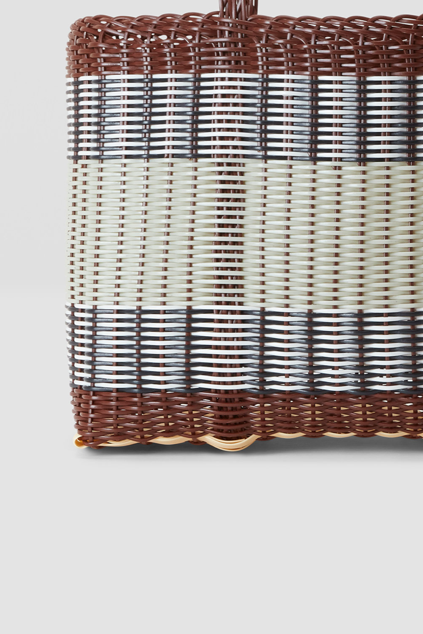 Woven basket with a gradient pattern on a light gray background