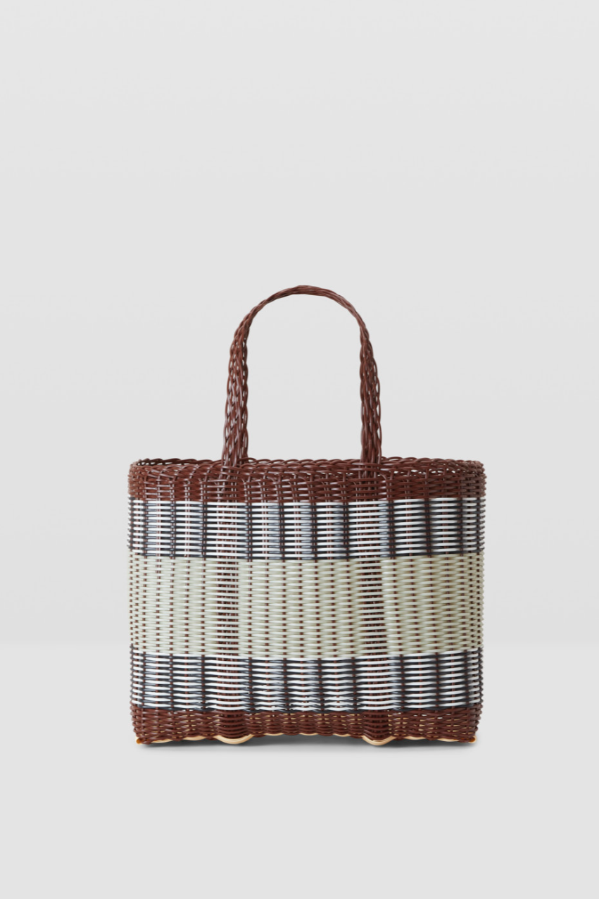 Woven handbag with brown handle and blue and white striped pattern on a light gray background