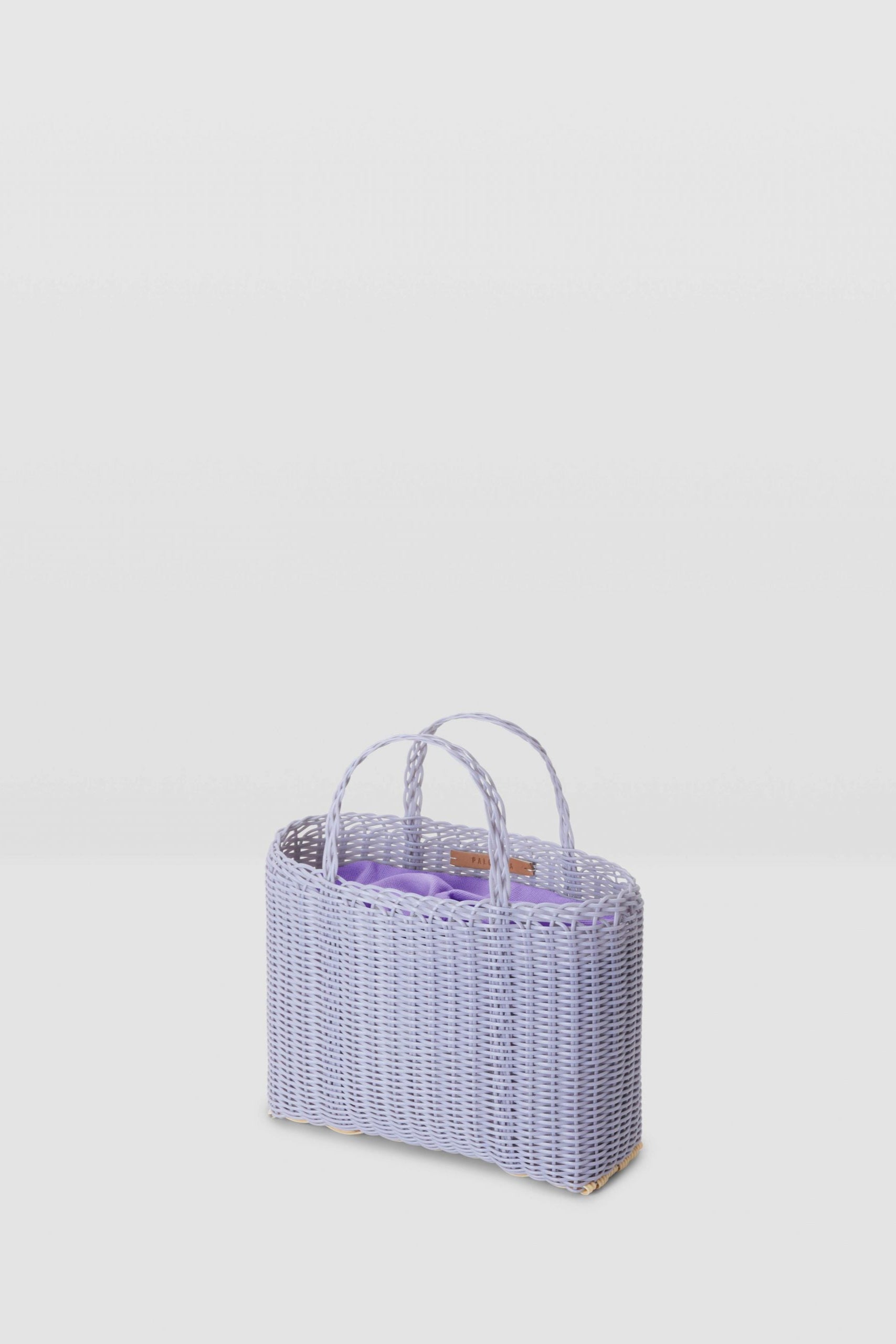 Wicker basket with a handle on a light gray background