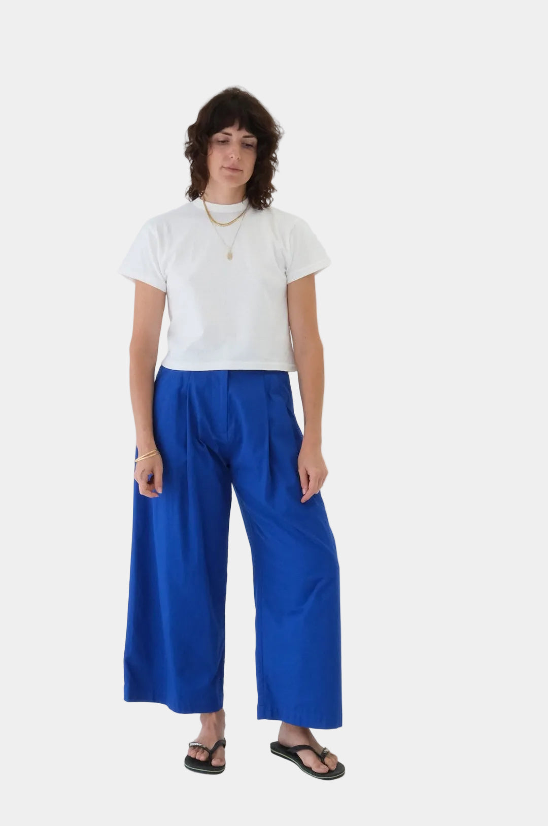 Person wearing a white t-shirt and blue pants on a white background