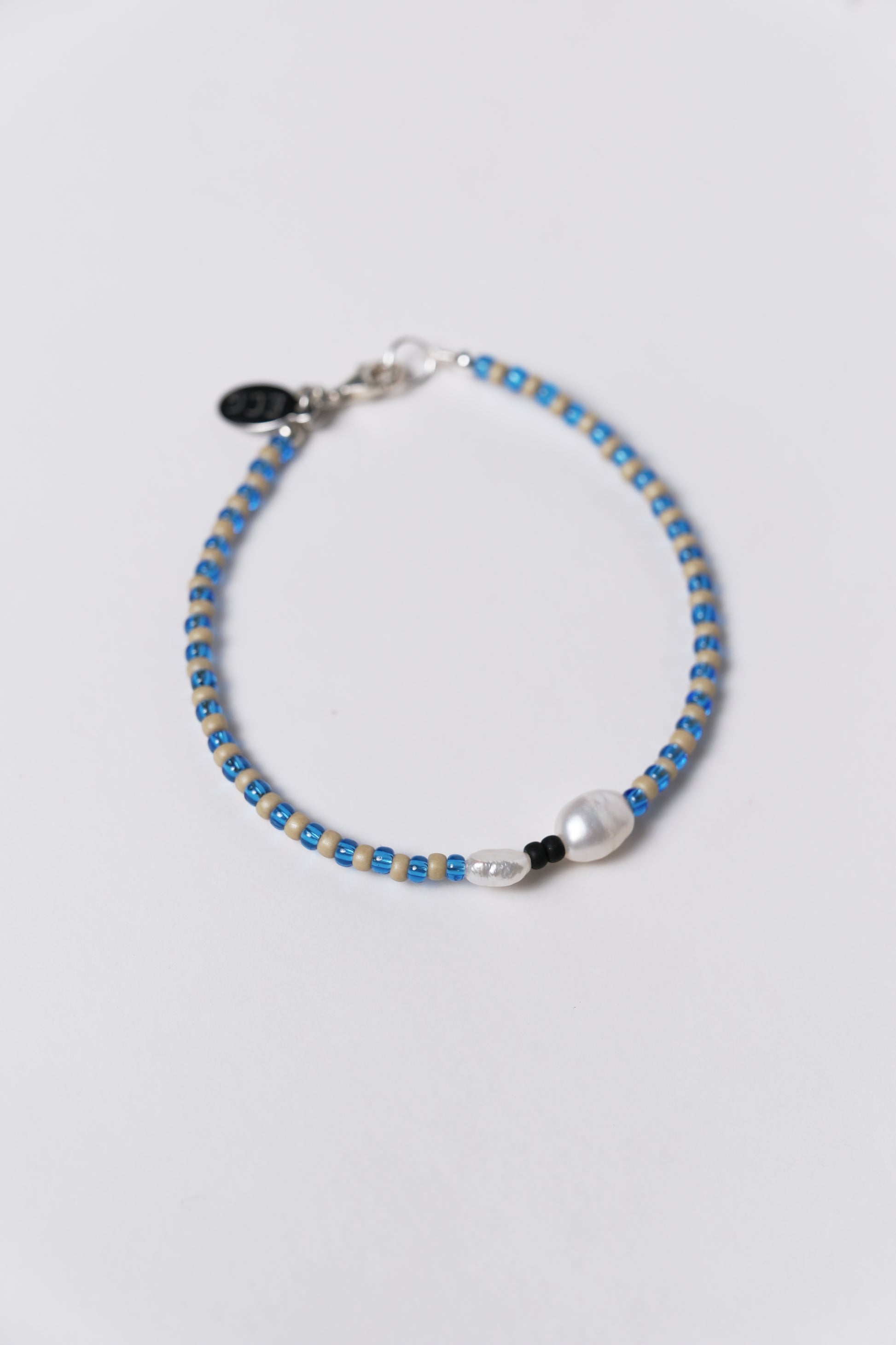 Beaded bracelet with blue and silver beads on a light gray background