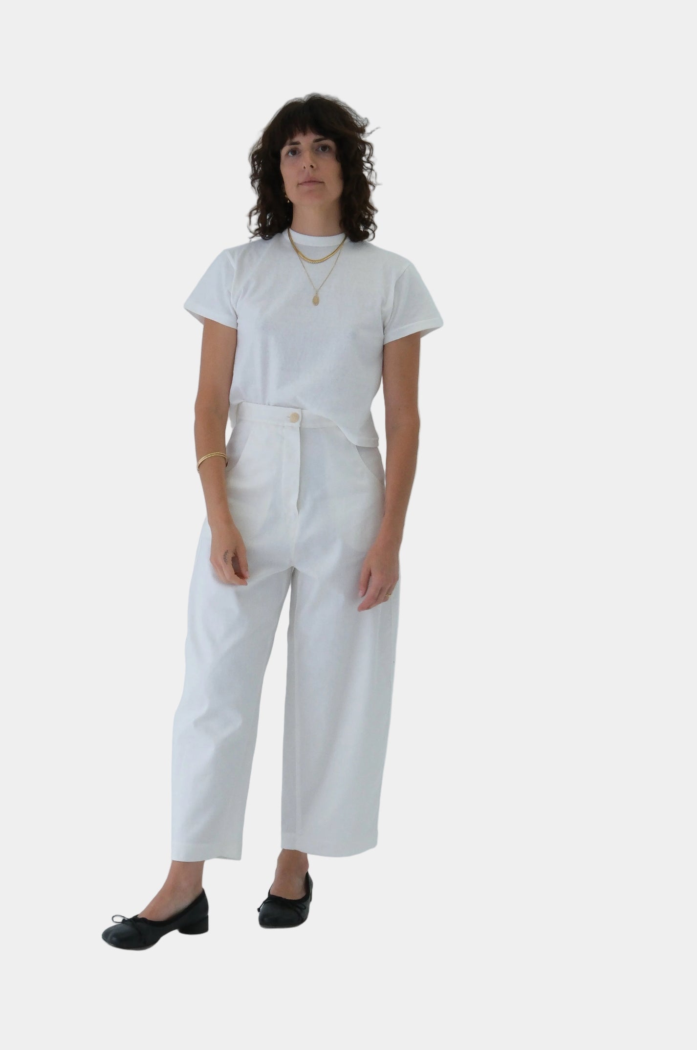 Person wearing a white t-shirt and pants on a light gray background