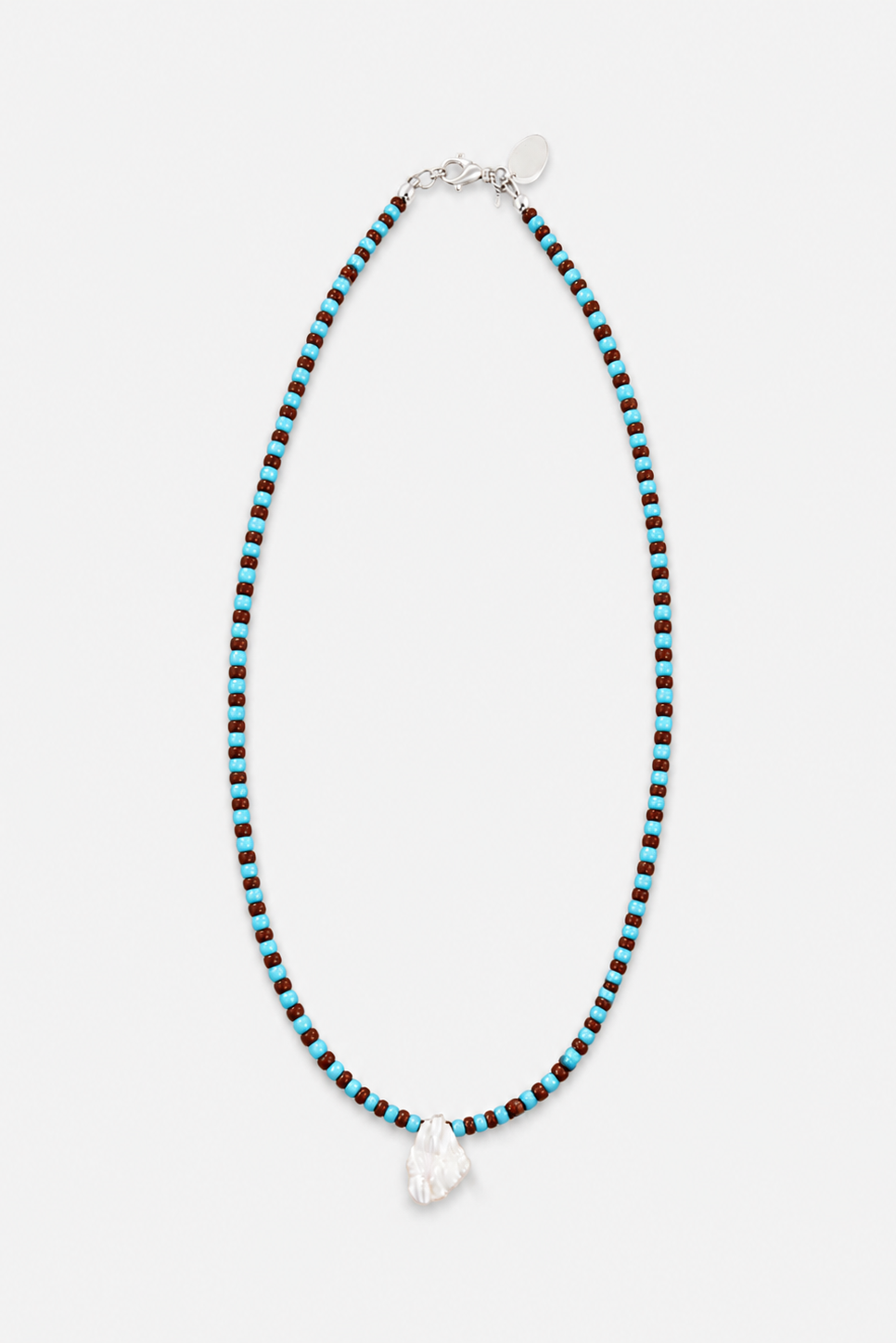 A beaded necklace featuring alternating turquoise blue and black beads, with a sterling silver clasp and a single freshwater pearl at the center, displayed on a light gray background.