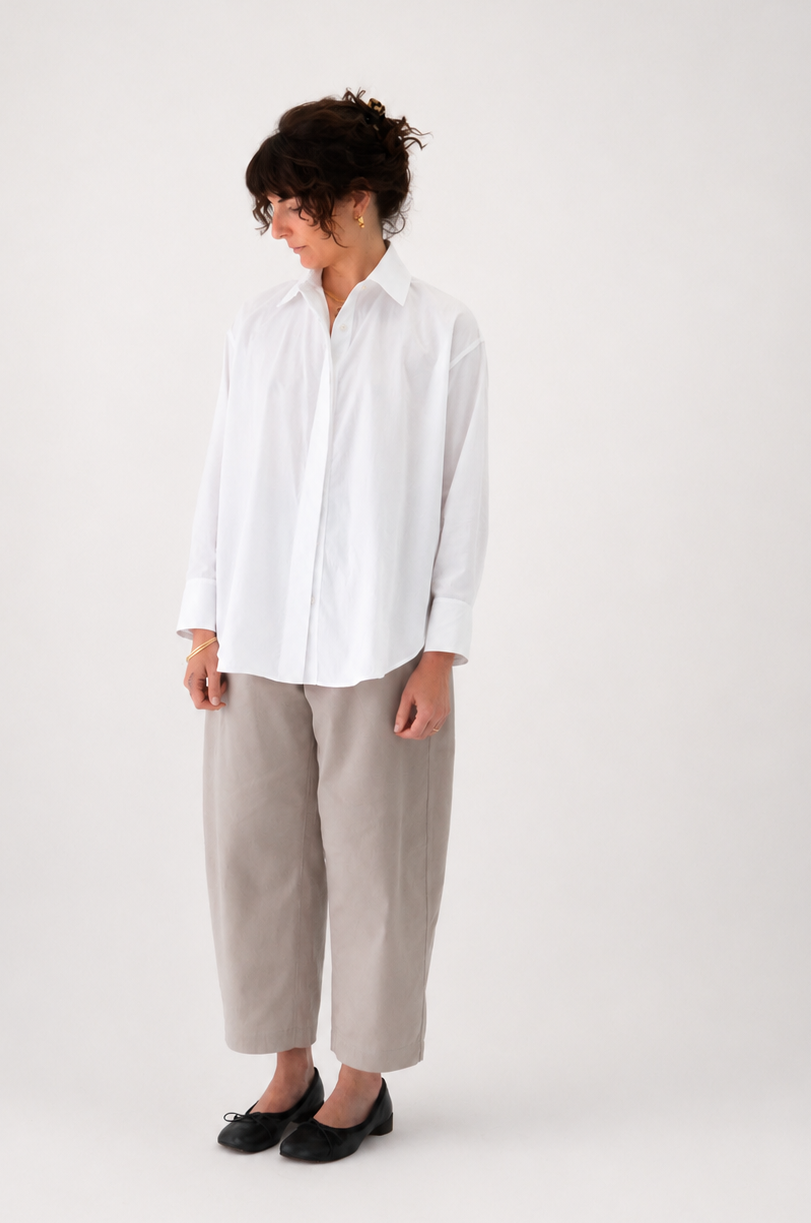Person wearing a white shirt and beige pants on a white background