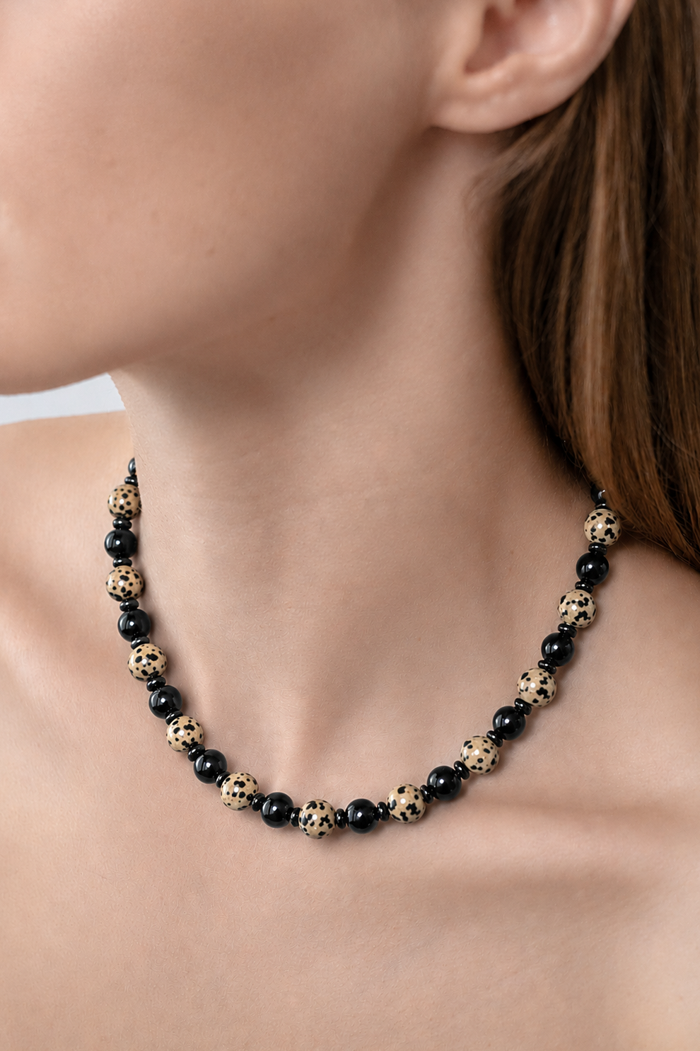 Necklace with black onyx and jasper beads, close up on a persons neck
