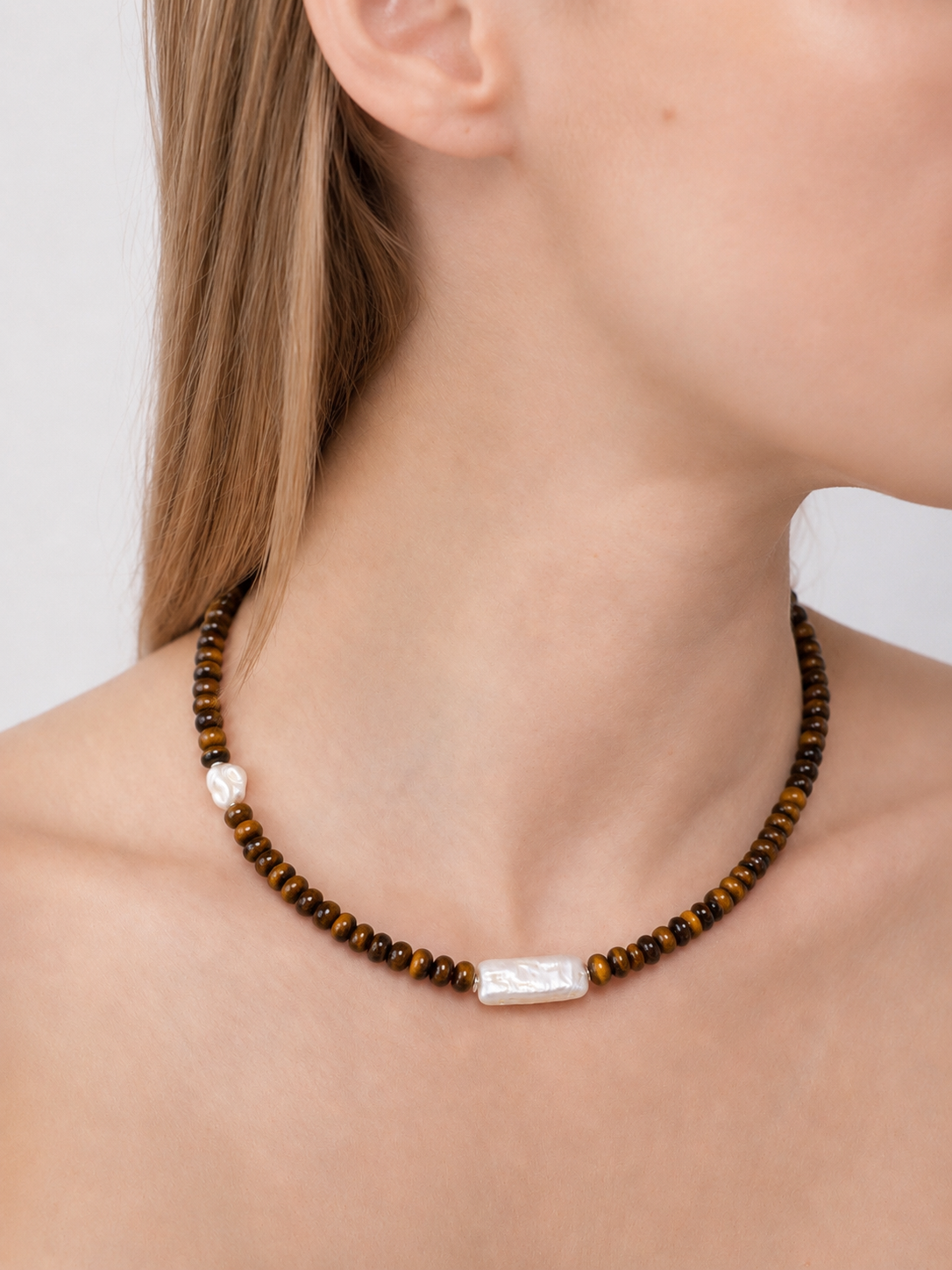 No. 65 necklace with tiger eyes and fresh water pearls, displayed close up on a persons neck - east coast general