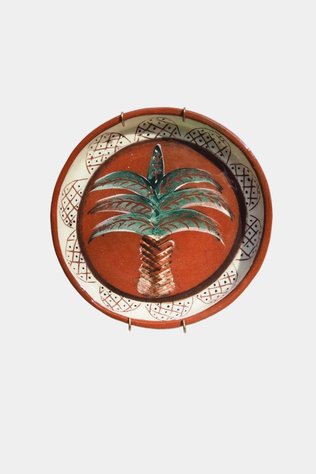 Decorative plate with palm tree design on a white wall
