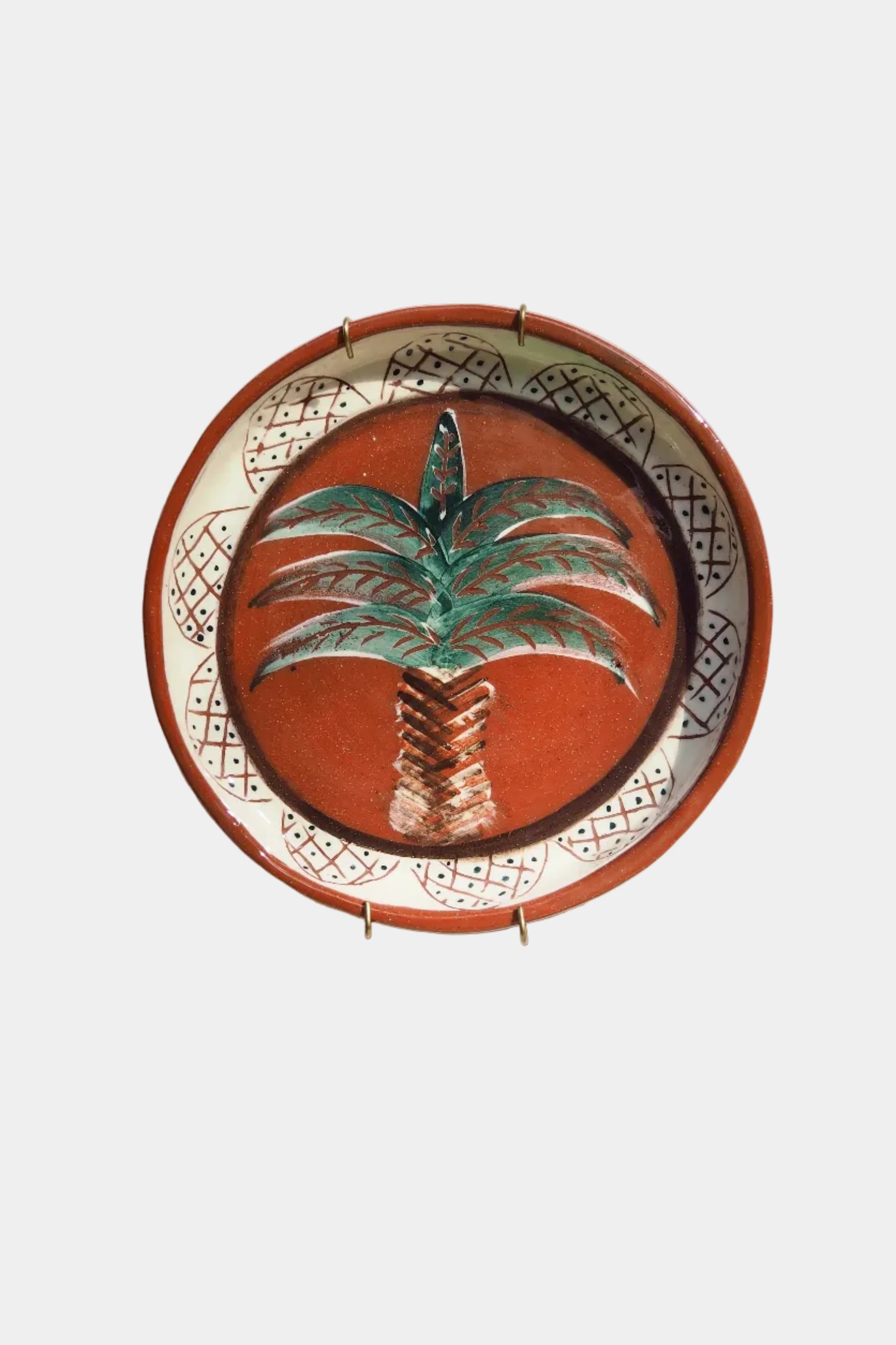 Decorative plate with palm tree design on a white wall