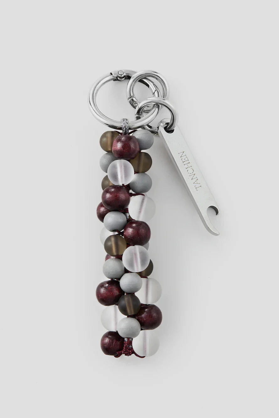 Keychain with multicolored beads and a metal tag on a white background