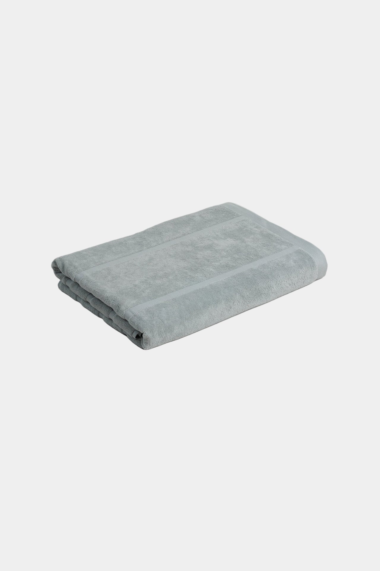 Folded light blue towel on a white background