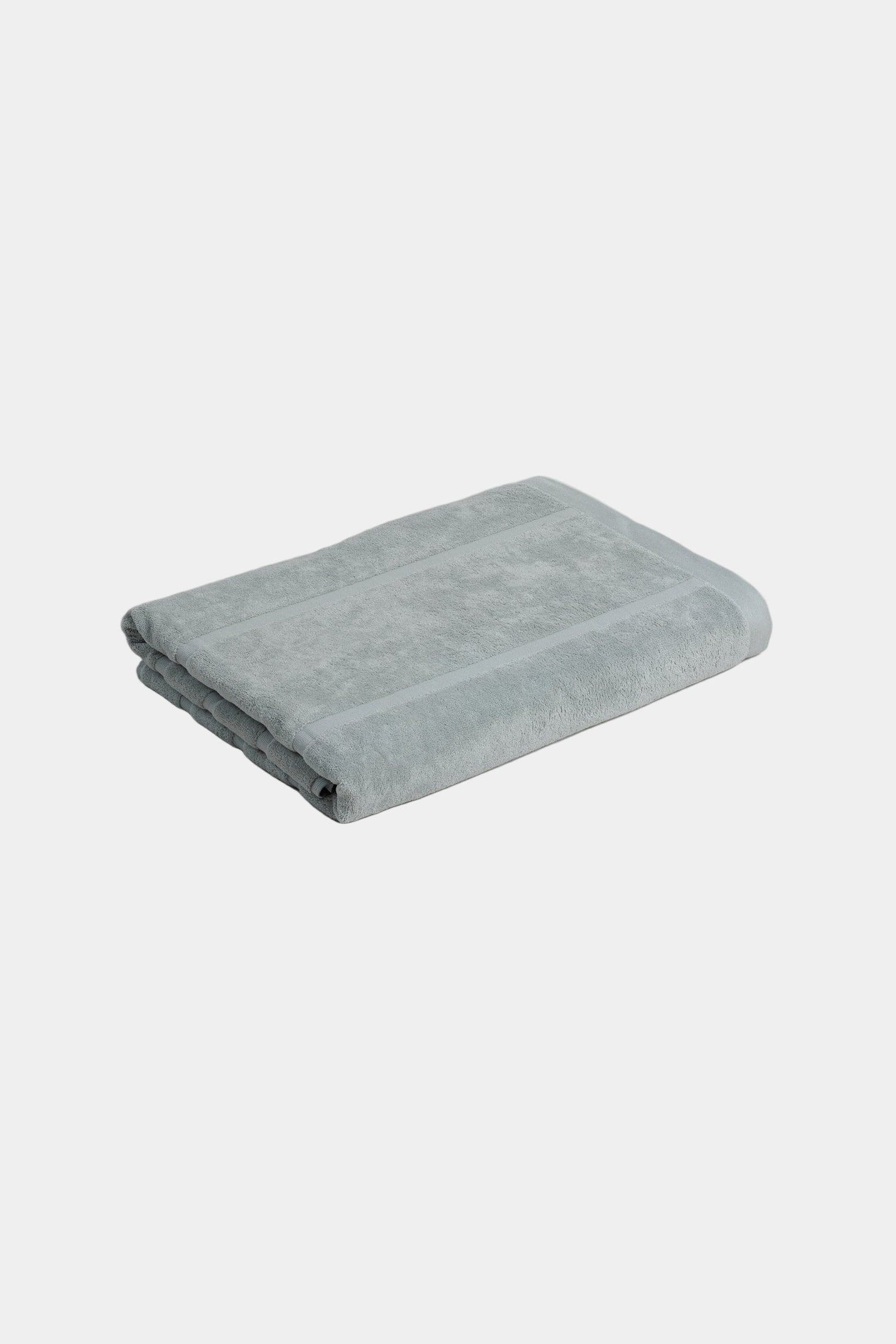 Folded light blue towel on a white background
