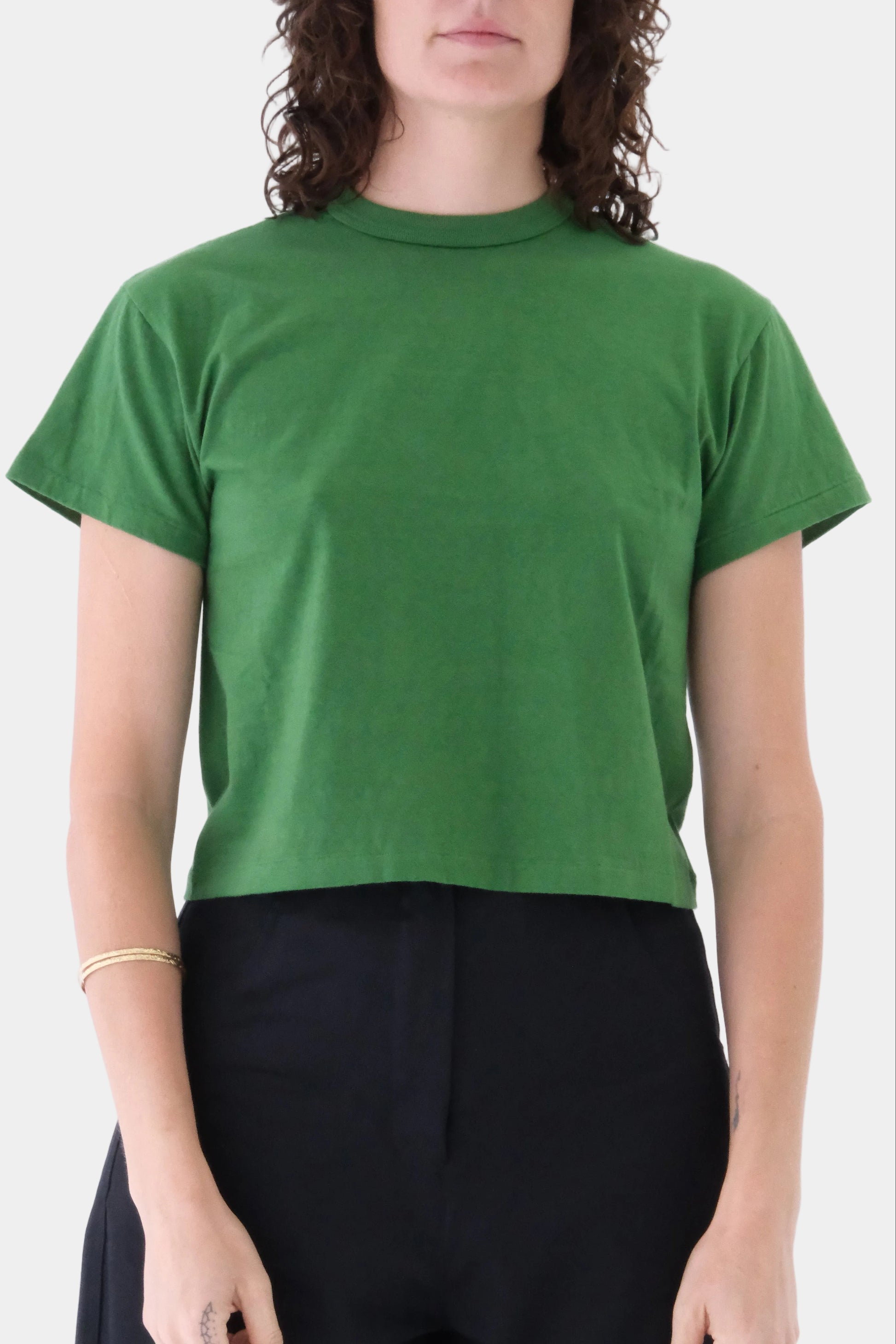 Person wearing a green t-shirt against a white background