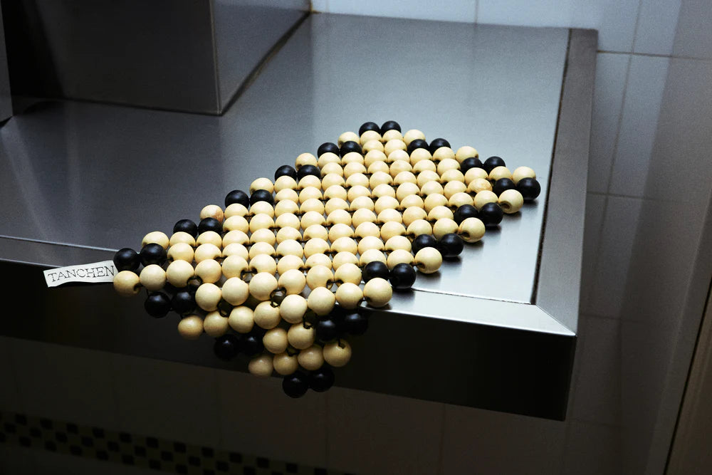 Black and white spherical objects arranged in a pattern on a metallic surface.