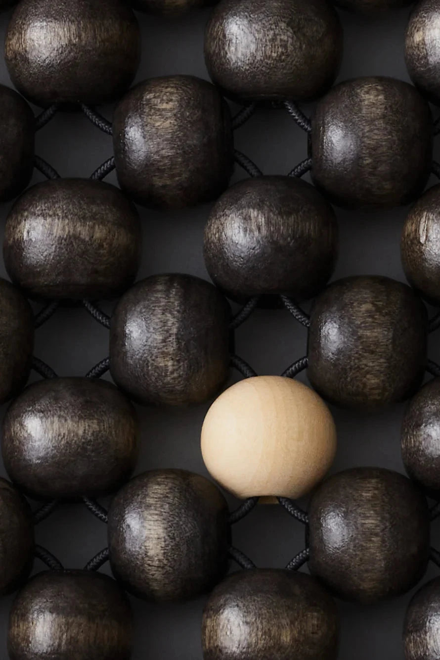 Square mat with a grid of wooden beads on a light gray background