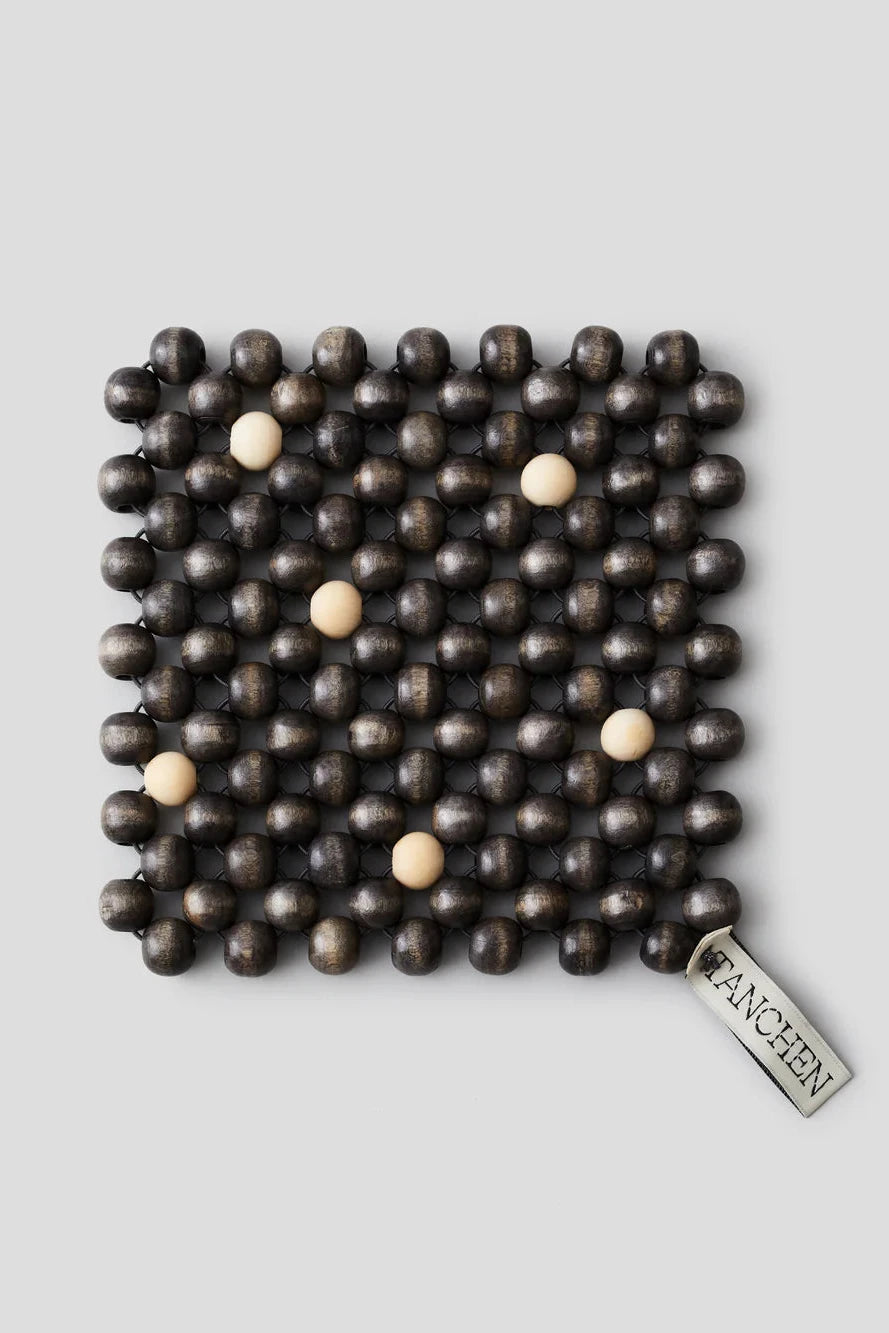 Square mat with a grid of wooden beads on a light gray background