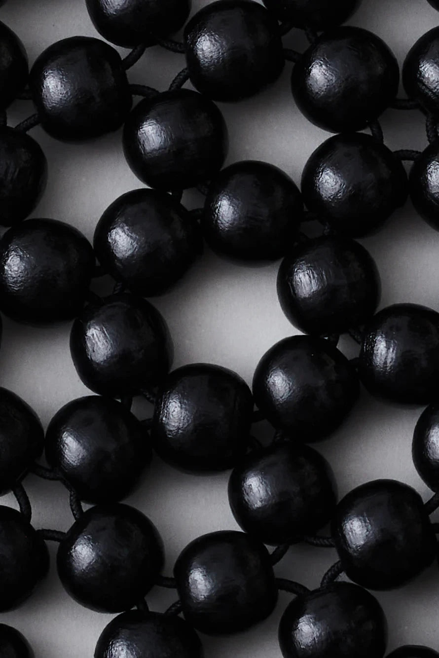 Close-up of black beads on a white background