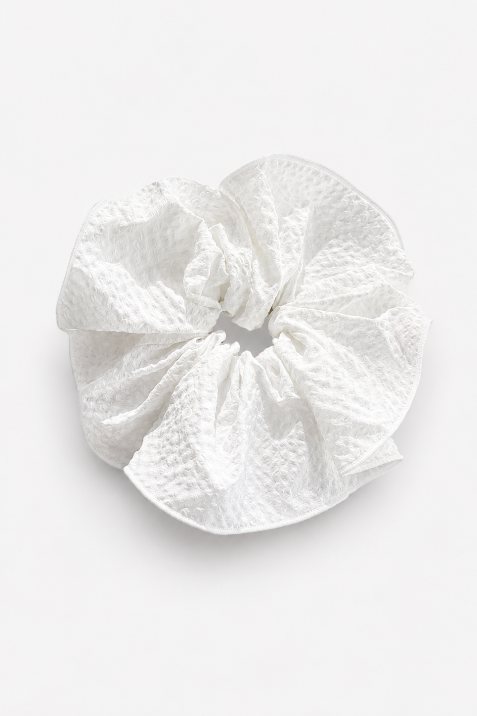 White textured scrunchie on a light gray background