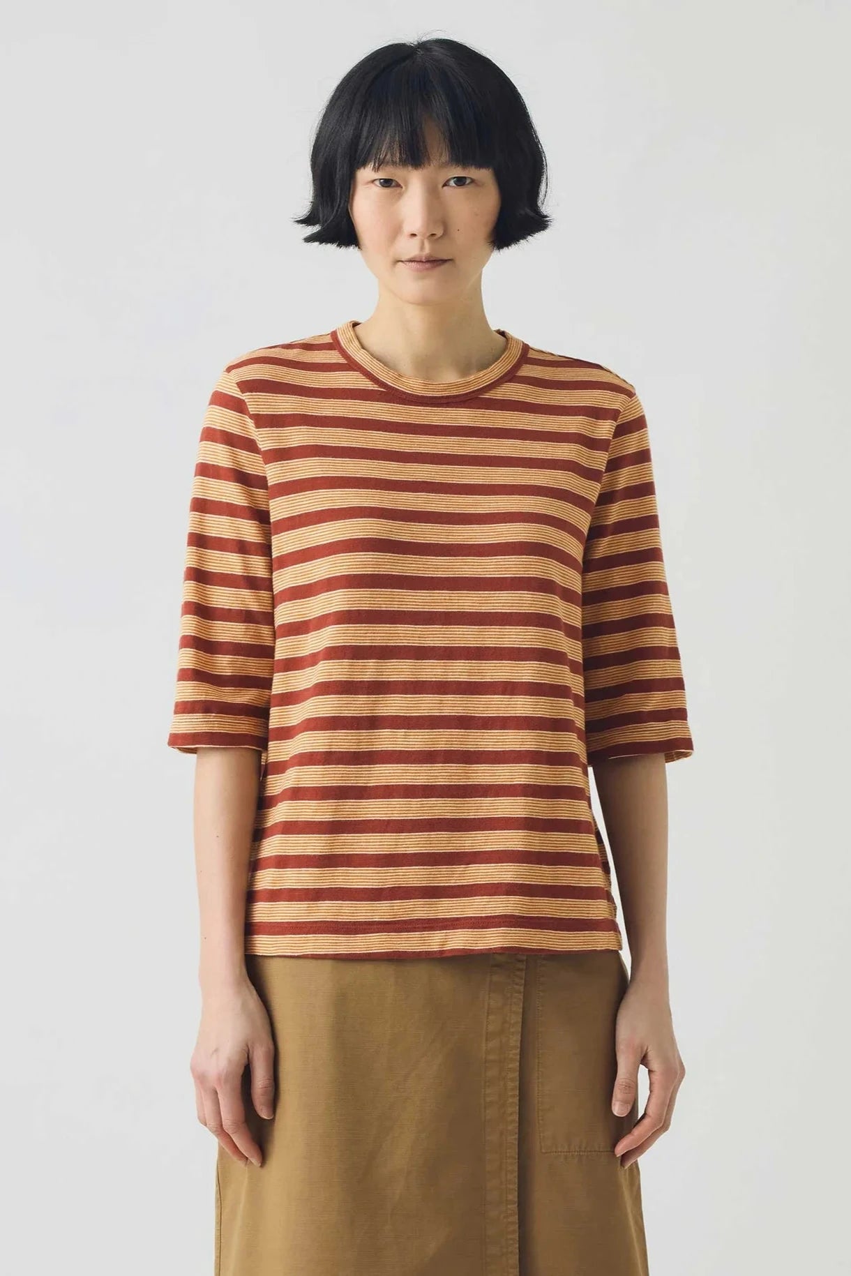 Striped shirt with brown and beige pattern on a light gray background