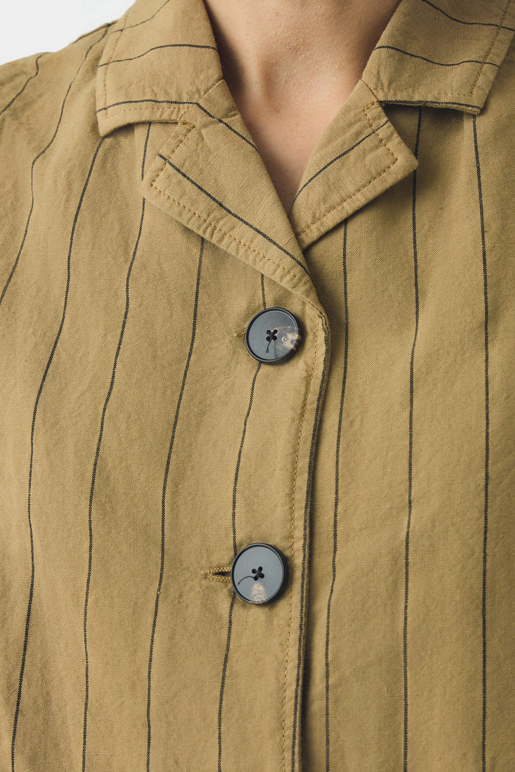 Close-up of a beige pinstripe waistcoat  with buttons
