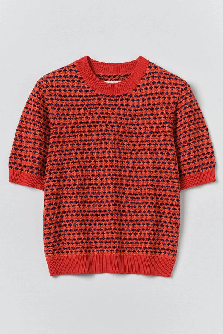 Red and black patterned sweater on a light gray background