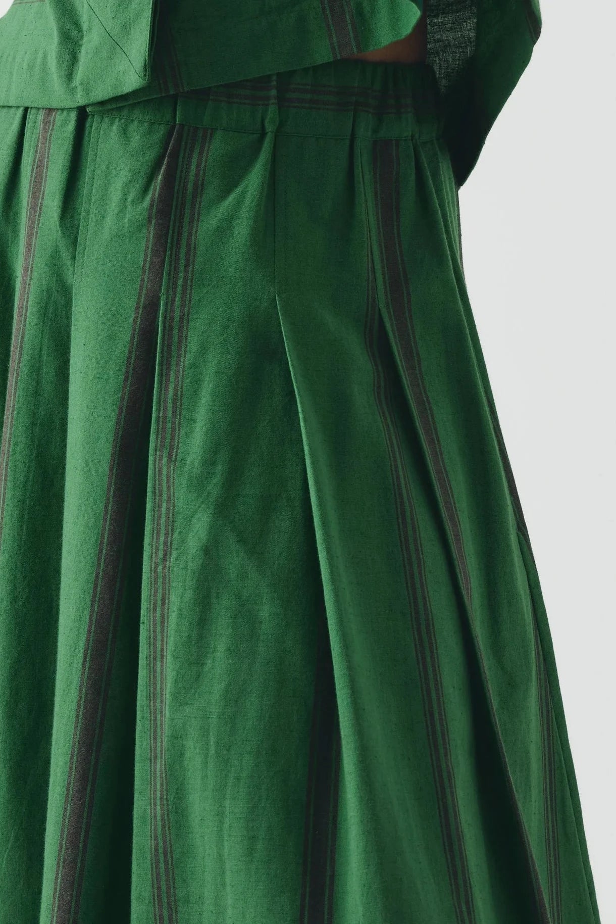 Green dress with black stripes on a white background