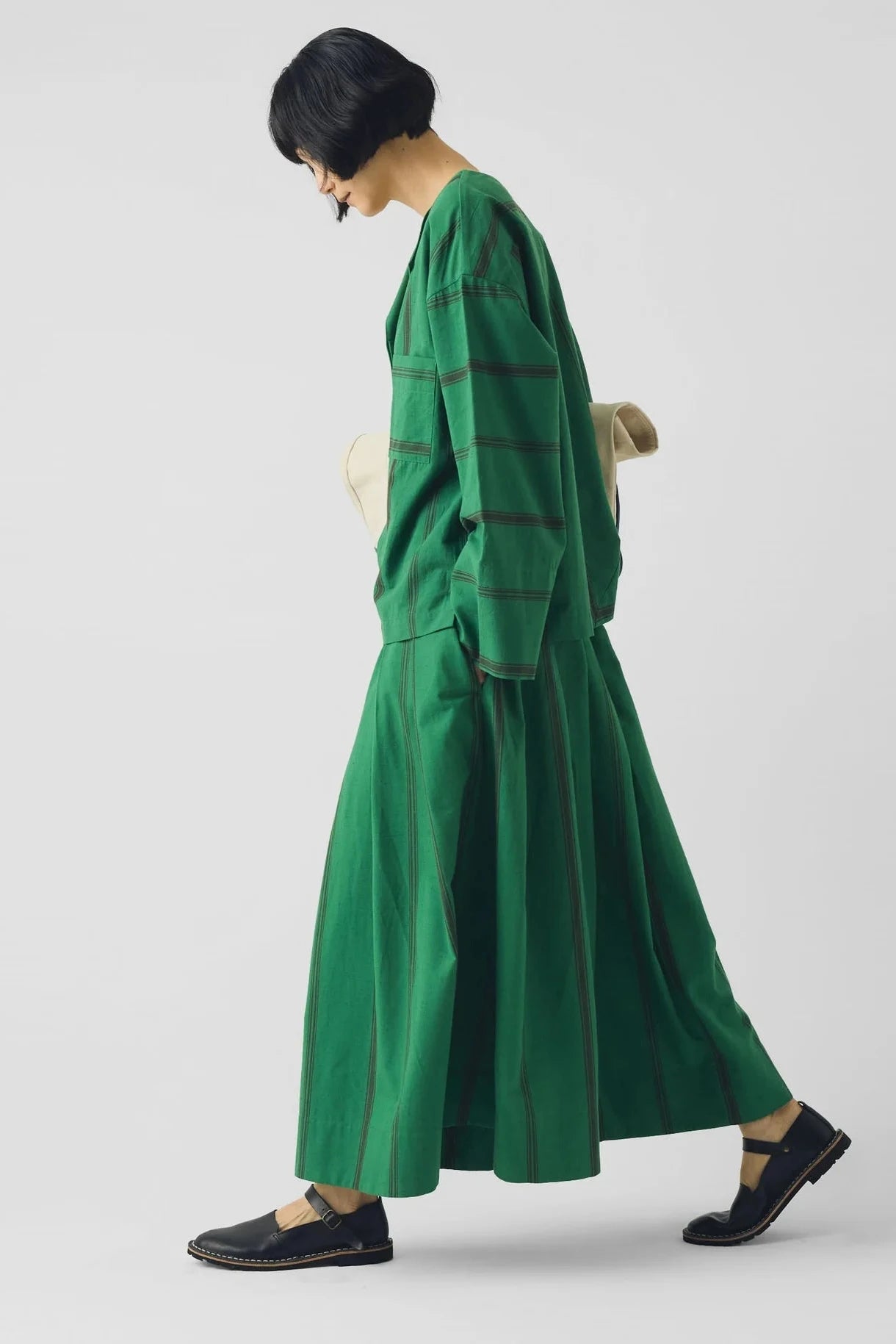 Person wearing a green dress with a plain background