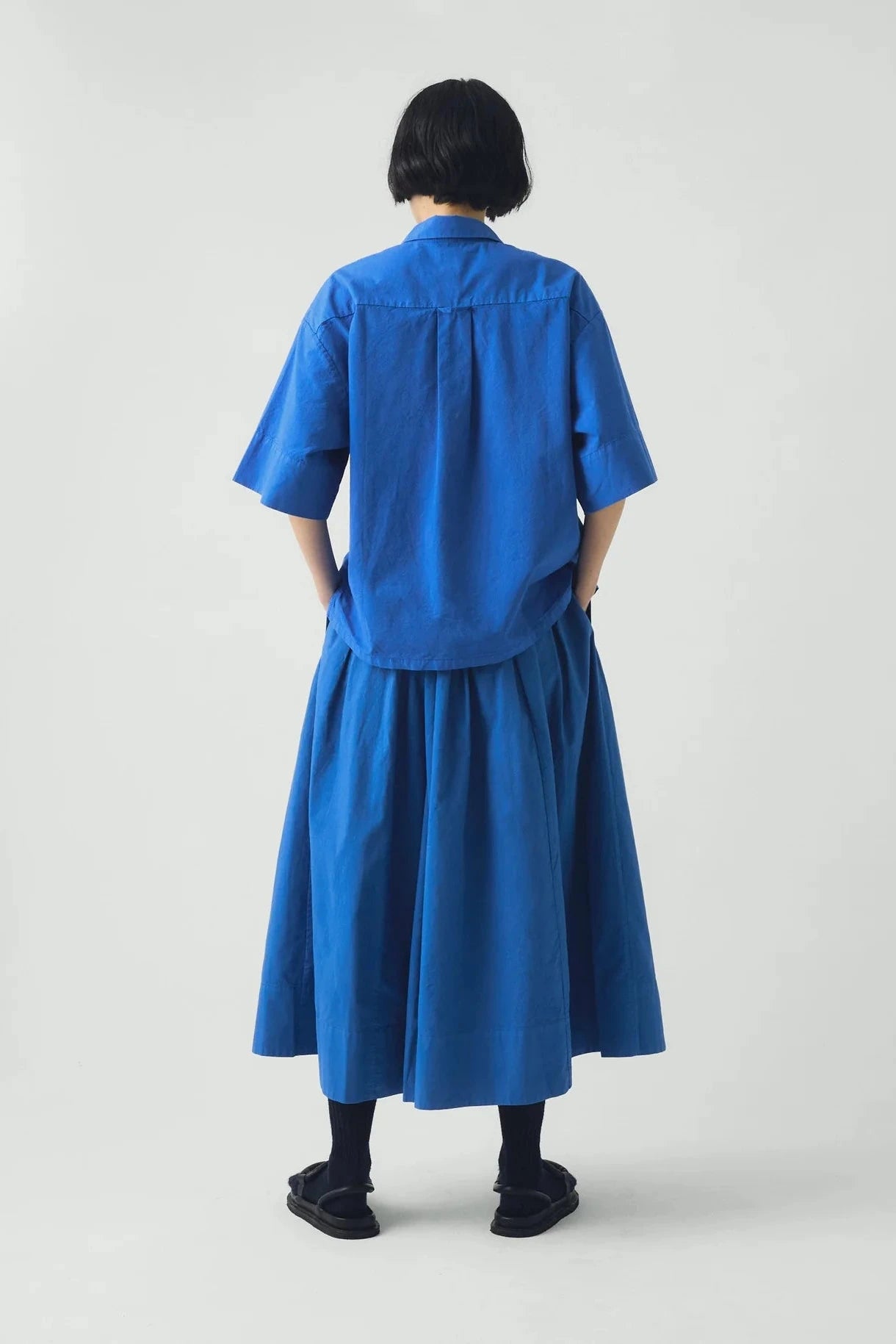 Person wearing a blue outfit with a plain background