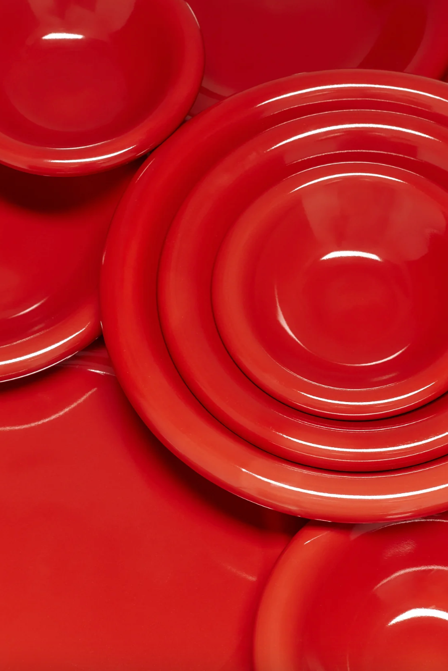 Stack of tomato red snack plates on a white background