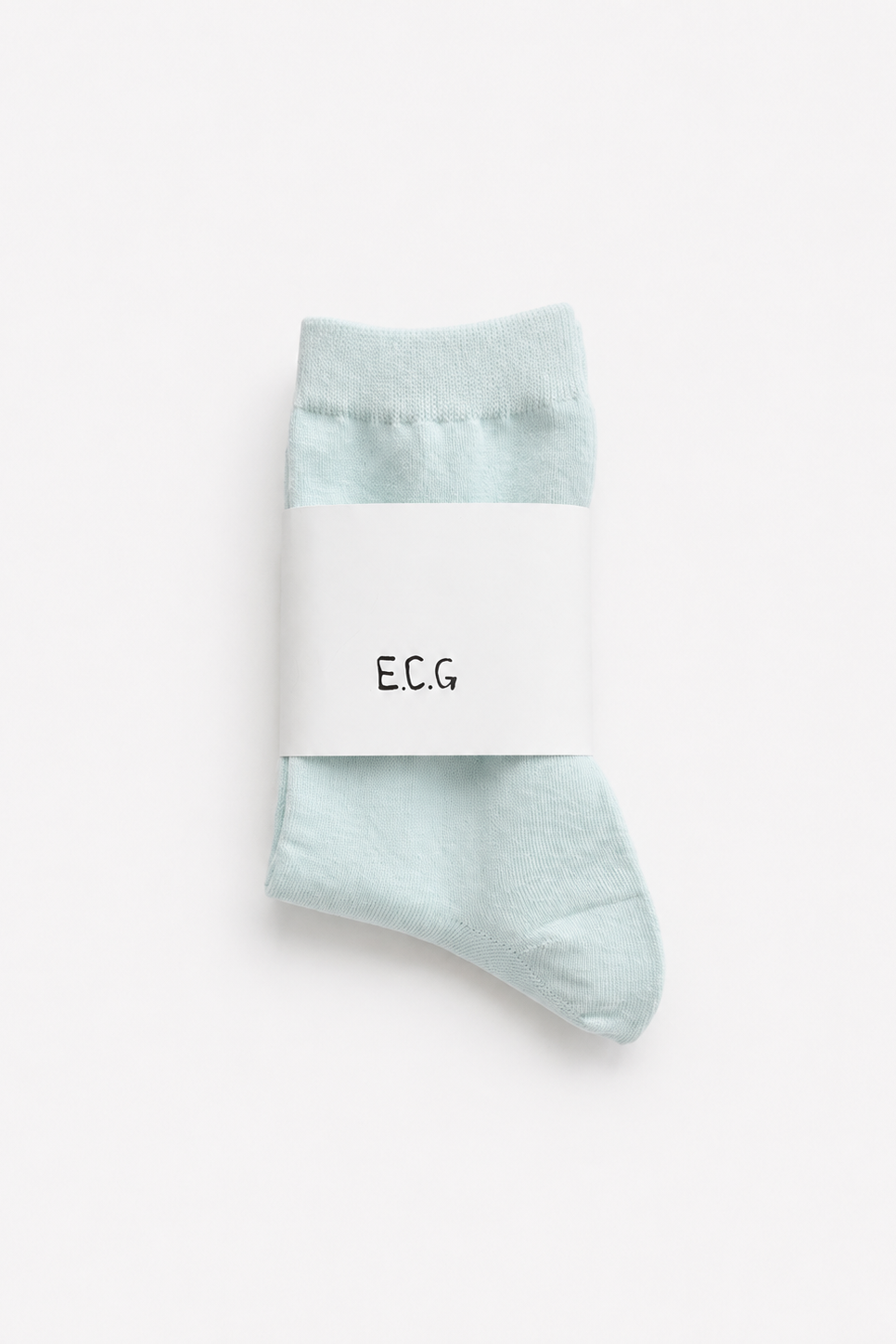 A pair of light baby blue cotton crew socks wrapped in a white paper band with the brand name 'E.C.G - East Coast General